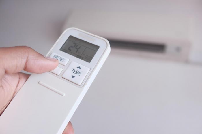 ręka trzymająca pilot klimatyzatora